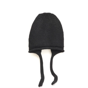 Dettaglio del cappello invernale nero in maglia a coste con paraorecchie e lacci lunghi