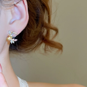 Macro shot of silver needle flower earrings with sparkling blue and pink crystals