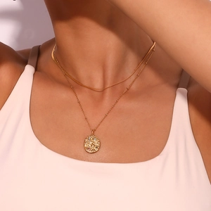 Close-up of 18K gold-plated double-layer necklace with celestial relief pendant on neck
