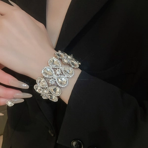 Close-up of wide silver rhinestone bracelet with pear-shaped crystals on model wrist