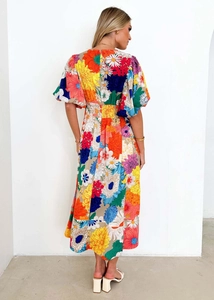 Back view of a long floral A-line dress with colorful prints and puff short sleeves