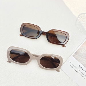 Detailed view of oval vintage sunglasses in translucent tea and cream grey frames