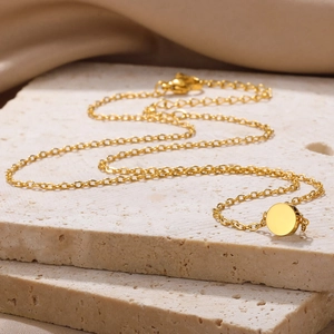 Macro view of gold-plated stainless steel coin pendant with adjustable lobster clasp chain