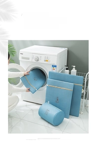 Detail of blue mesh laundry bags with embroidery icons next to a washing machine