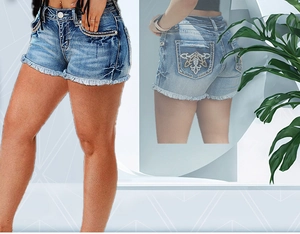 Detail of high waist denim shorts with floral embroidery and distressed raw hem on back pocket