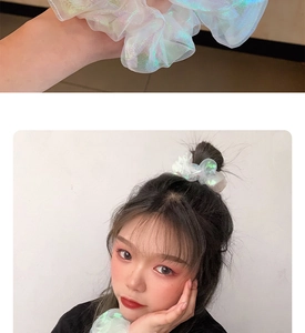 Detailed view of white iridescent organza scrunchies on wrist and in hair styling