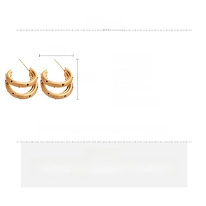 Dettaglio orecchini a C placcati oro 18k con pois neri e perno in argento dal design moderno