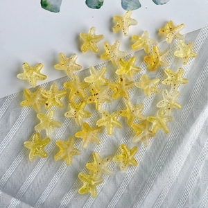 Close-up of translucent yellow acrylic starfish beads with brown spots for DIY jewelry