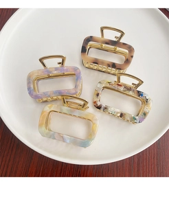 Detailed view of assorted acetate rectangle hair claws in marble and tortoiseshell patterns