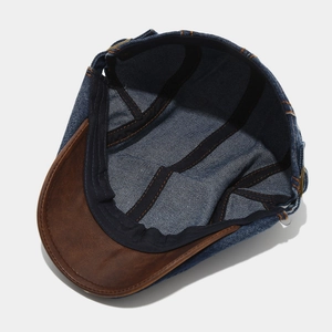 Detailansicht der Jeans-Schirmmütze mit schwarzem Innenband und orangefarbenen Nähten