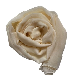 Ivory silk scarf for women styled in a spiral rose fold for elegant beach sun protection