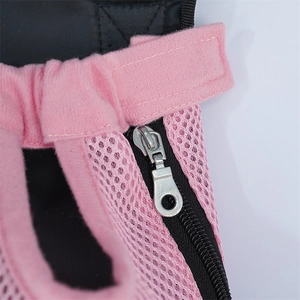 Close-up of pink breathable mesh fabric and durable metal zipper on a pet carrier backpack
