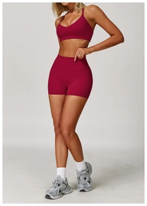 Dettaglio del reggiseno sportivo rosso bacca e dei pantaloncini fitness aderenti