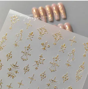 Macro detail of gold embossed nail art stickers with baroque vines and star patterns