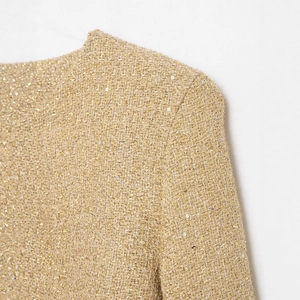 Elegant gold tweed jacket with sparkling sequins and detailed metallic weaving