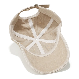 Macro view of khaki washed cotton baseball cap interior with white seam tape and metal buckle
