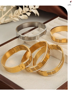 Detailed view of layered bangle bracelets with hollow H design and sparkling diamonds