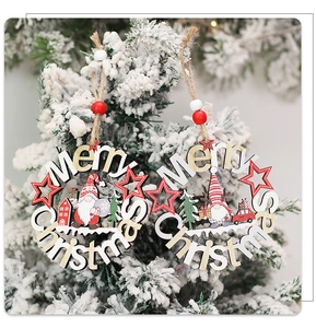 Detail of wooden Merry Christmas gnome pendants hanging on a snowy tree branch