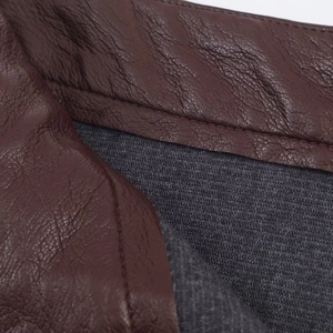 Dettaglio delle cuciture sottili e della texture in pelle marrone della gonna midi