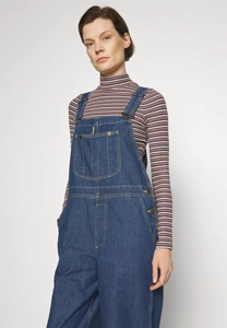 Detail view of retro denim overalls with metal buckles and front pocket styling