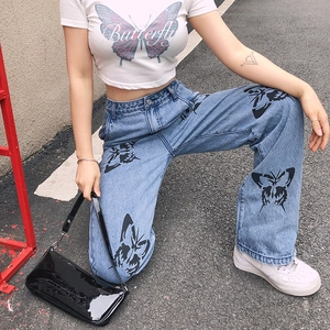Close-up of slim denim jeans featuring intricate butterfly prints and high-waist cut