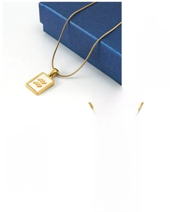 Detailed macro of 18K gold plated stainless steel square zodiac pendants on snake chains