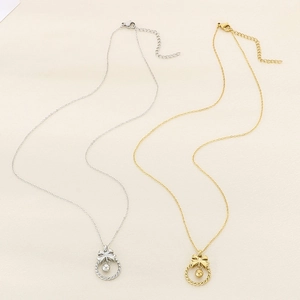 Détail des pendentifs nœud et anneau torsadé sur des colliers en or et en argent