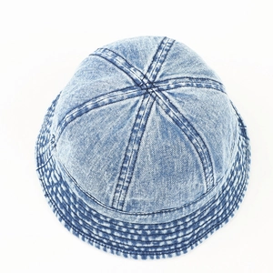 Détail d'un chapeau bob en denim délavé avec coutures parallèles sur le bord