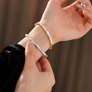 Detail of bamboo joint style gold and silver plated bracelets on a model wrist