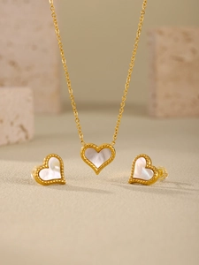 Detail of gold-edged heart necklace and earrings set with white mother of pearl inlay