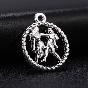 Macro detail of antique silver Gemini zodiac pendant with intricate rope edge design