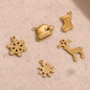 Dettaglio di ciondoli natalizi placcati in oro 14K con renne e motivi a fiocco di neve
