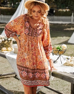 Détail du col en V et de l'imprimé bohème sur la robe d'été orange de vacances
