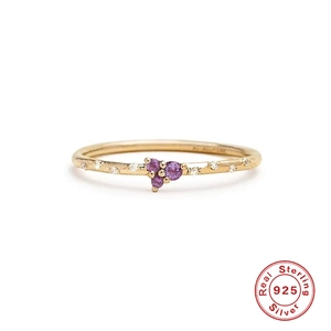 Detail of 925 sterling silver ring with cluster of purple gems and gold finish