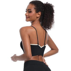 Detail of cross straps and white V-shape contrast trim on back of black sports bra