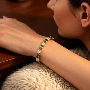 Close-up of 18k gold plated bracelet with green rectangle and white round zircons