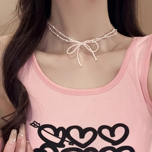 Gros plan d'un collier à double couche de perles roses avec un nœud papillon mignon
