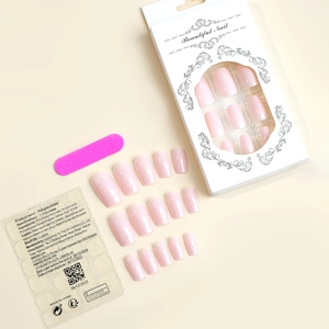 Detail of light pink long press-on nails set with packaging and manicure accessories
