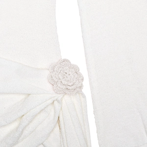 Detailaufnahme von weißem Strickgewebe mit einer 3D-gehäkelten Blumendekoration