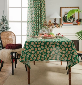 Detail of green Christmas tablecloth featuring gingerbread man and snowflake patterns