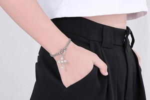 Close-up of double-layer stainless steel bracelet with OT toggle and cross pendant