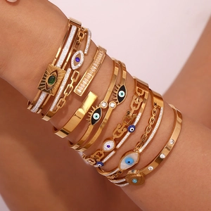 Layered gold evil eye bracelets and bangles set with sparkling crystals on a female wrist