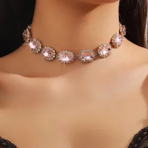 Close-up of a layered golden choker with large oval pink crystals and white rhinestones
