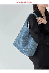 Close-up of the large blue woven denim tote bag with detailed interlaced leather texture
