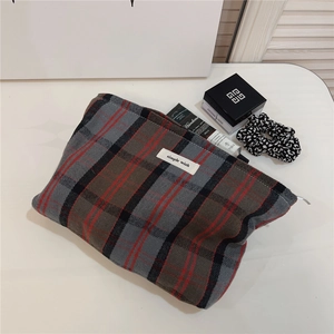 Close-up of British style plaid cotton pouch with zipper and simple wish label