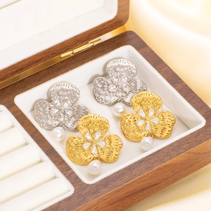 French vintage clover earrings with diamonds and pearls displayed in a wooden jewelry box