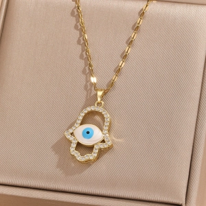 Gold Hamsa Hand necklace with Evil Eye pendant and white rhinestones on silk