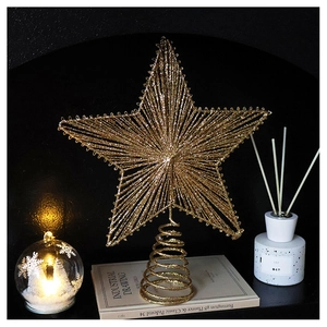 Close-up of a golden hollow wire star tree topper on vintage books with warm ambient lighting