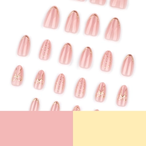 Faux ongles amande oeil de chat rose avec nœud doré 3D et détails French pailletés