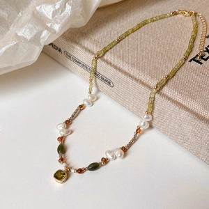 Detailed close-up of handmade vintage beaded necklace with green gemstone and pearls